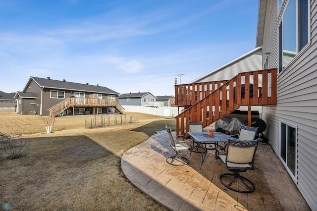 view of yard with stairs, outdoor dining space, a patio area, and a fenced backyard