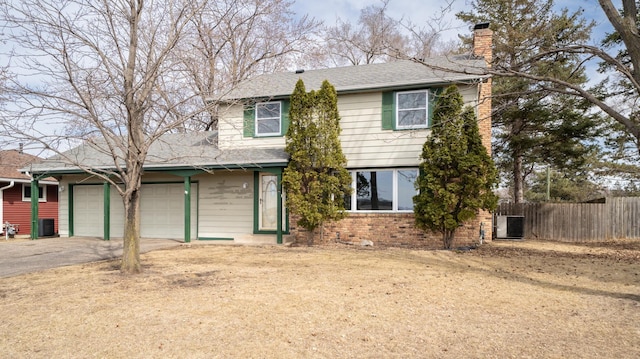 traditional home with aphalt driveway, cooling unit, fence, and a chimney