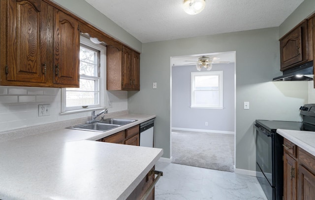 kitchen featuring electric range, a sink, under cabinet range hood, light countertops, and dishwasher