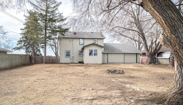 back of house with a garage and a fenced backyard