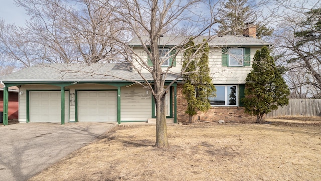 view of front of house featuring fence, driveway, a chimney, a garage, and brick siding