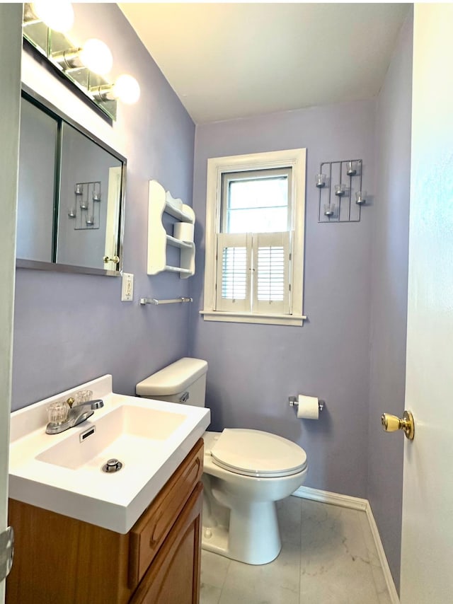 bathroom featuring tile patterned floors, baseboards, toilet, and vanity