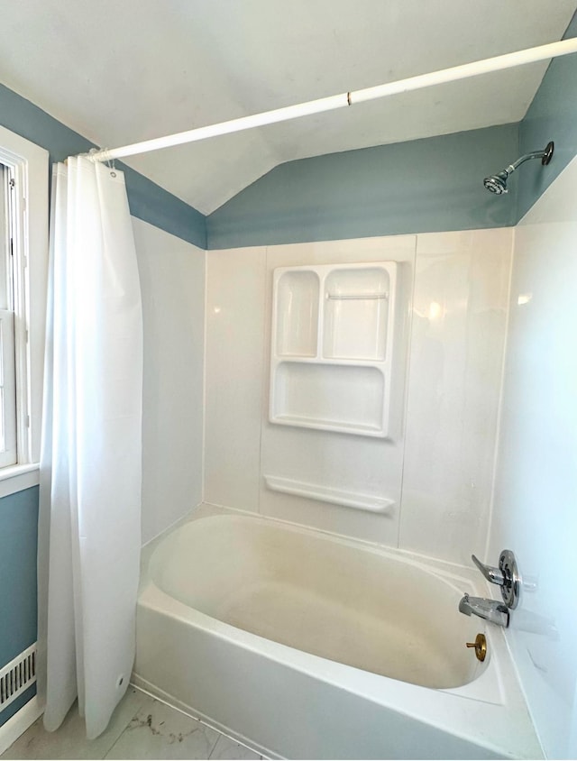 bathroom featuring shower / bathtub combination with curtain and vaulted ceiling