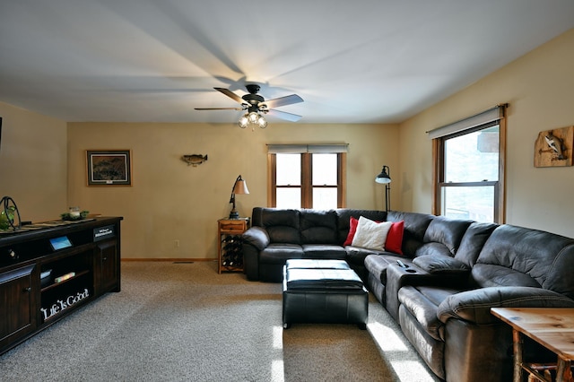 living room featuring baseboards, light carpet, a healthy amount of sunlight, and a ceiling fan