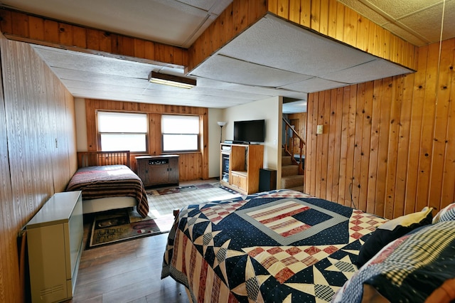 bedroom with wood finished floors and wood walls