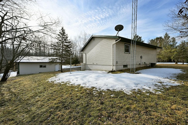 view of snowy exterior featuring central AC unit and an outdoor structure