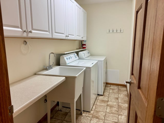 clothes washing area featuring cabinet space, independent washer and dryer, and baseboards