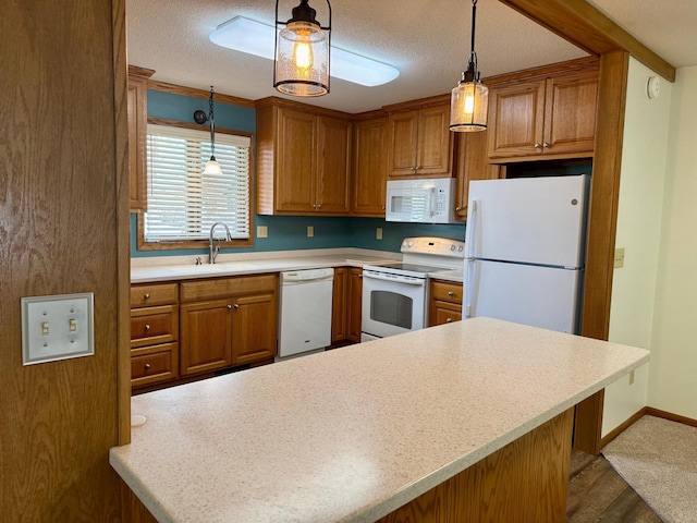 kitchen with decorative light fixtures, light countertops, brown cabinetry, white appliances, and a sink