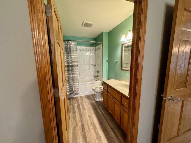 bathroom featuring vanity, wood finished floors, visible vents, toilet, and shower / tub combo with curtain