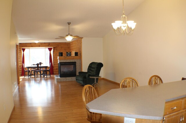12170 Hillcrest Ct SE, Becker, MN 55308 - dining area with a tiled fireplace, baseboards, ceiling fan with notable chandelier, and light wood-type flooring