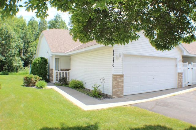 12170 Hillcrest Ct SE, Becker, MN 55308 - view of front of house with a garage, roof with shingles, a front yard, and asphalt driveway