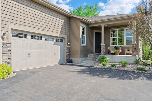 6627 133rd St, Savage, MN 55378 - view of front facade featuring asphalt driveway, a porch, stone siding, and a garage