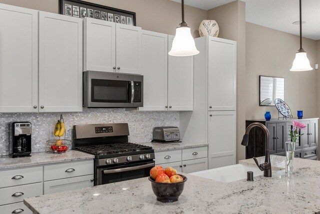 6627 133rd St, Savage, MN 55378 - kitchen featuring stainless steel appliances, a sink, decorative backsplash, and white cabinetry
