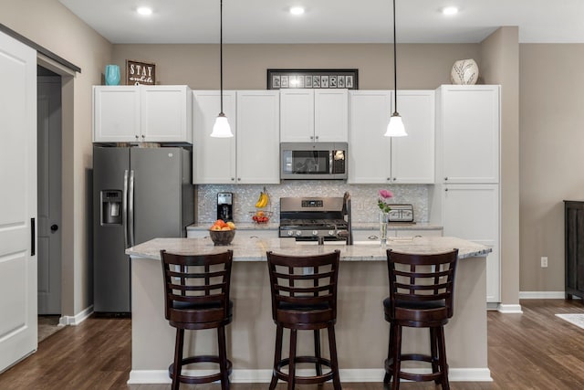 6627 133rd St, Savage, MN 55378 - kitchen with stainless steel appliances, a center island with sink, dark wood-style flooring, decorative backsplash, and recessed lighting