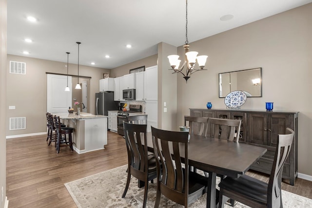 6627 133rd St, Savage, MN 55378 - dining room with a chandelier, light wood-style flooring, recessed lighting, and baseboards