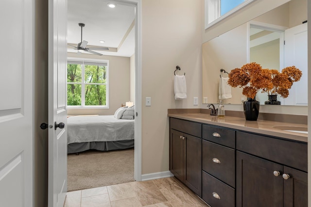 6627 133rd St, Savage, MN 55378 - bathroom featuring double vanity, connected bathroom, a ceiling fan, baseboards, and a tray ceiling