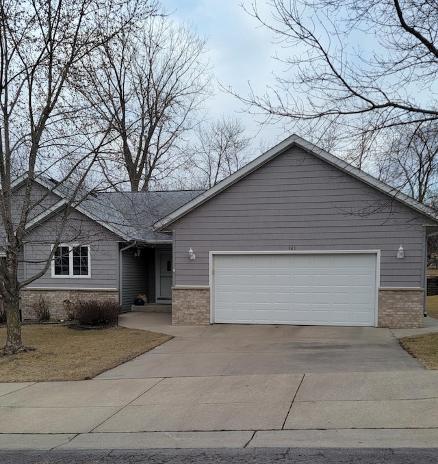 ranch-style home featuring brick siding, driveway, and an attached garage