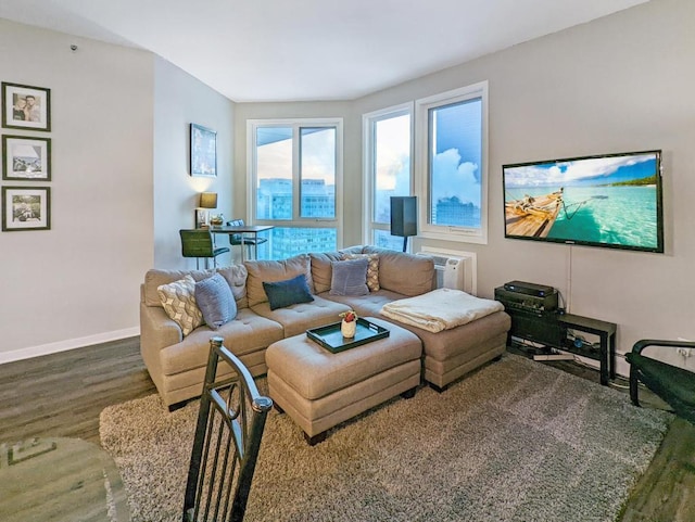 living area featuring an AC wall unit, wood finished floors, and baseboards