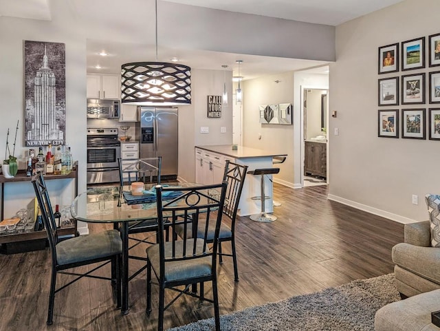 dining area featuring recessed lighting, baseboards, and dark wood finished floors