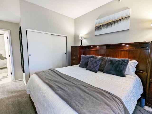 bedroom featuring ensuite bathroom, a closet, and carpet floors