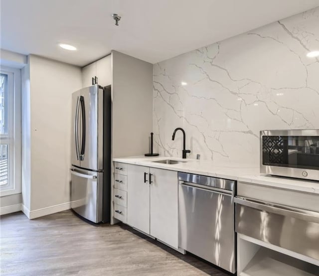 kitchen featuring a sink, a healthy amount of sunlight, tasteful backsplash, and stainless steel appliances