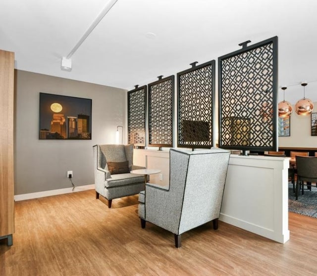 living area with baseboards and wood finished floors