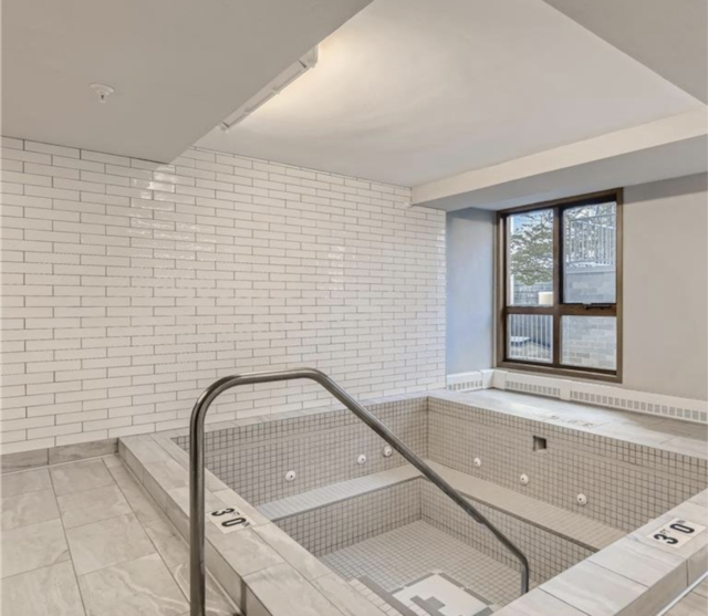 interior space with tile patterned flooring and brick wall