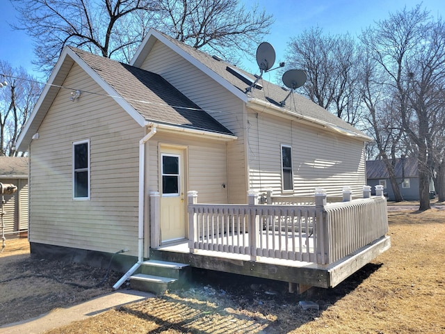 back of property featuring a deck and roof with shingles