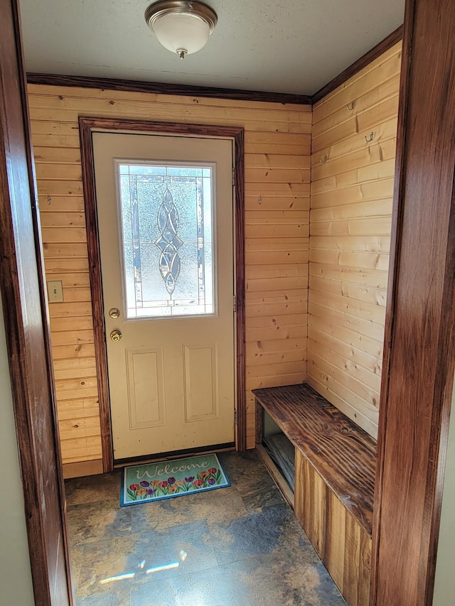 entryway with wooden walls and stone finish flooring