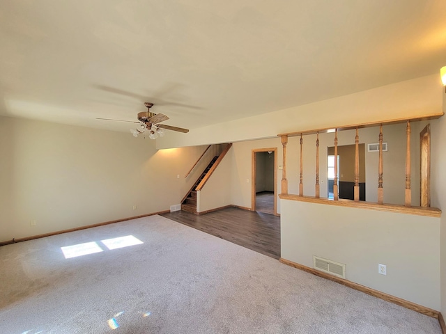 unfurnished room with visible vents, a ceiling fan, carpet flooring, and stairway