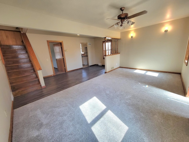 unfurnished living room featuring a ceiling fan, stairway, carpet, and baseboards
