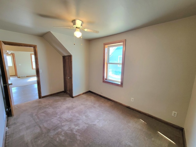 interior space featuring visible vents, baseboards, light colored carpet, and ceiling fan