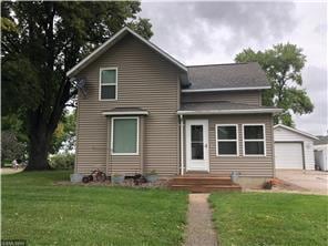 view of front of house with an outbuilding and a front yard