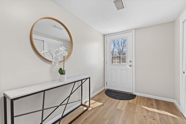 foyer with baseboards, visible vents, and light wood finished floors