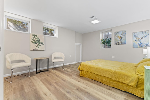 bedroom with visible vents, baseboards, and wood finished floors