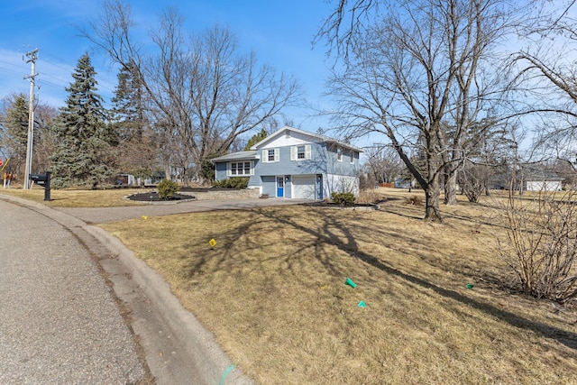 view of front facade featuring a front yard, a garage, and driveway