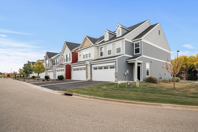 view of front of home featuring aphalt driveway, a residential view, an attached garage, and a front yard