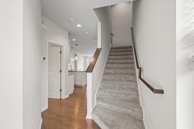 staircase with recessed lighting, baseboards, and wood finished floors