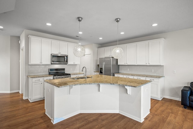 kitchen with appliances with stainless steel finishes, white cabinetry, dark wood-type flooring, and a sink