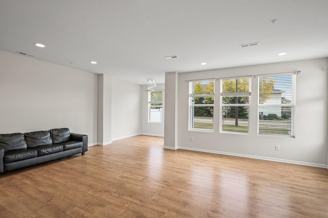 living area with light wood finished floors, plenty of natural light, recessed lighting, and visible vents