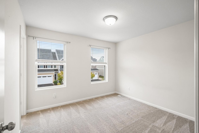 empty room featuring baseboards and carpet floors