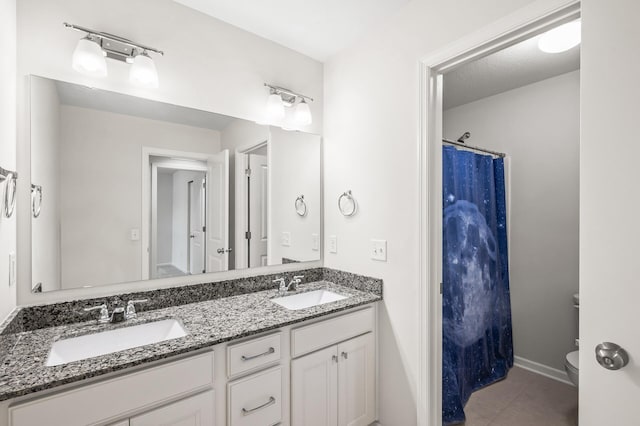 full bath featuring tile patterned flooring, double vanity, toilet, and a sink