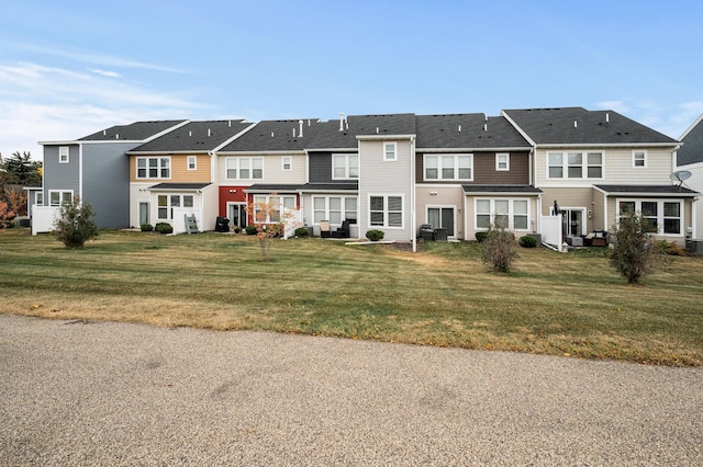 view of front of house with cooling unit, a residential view, and a front lawn