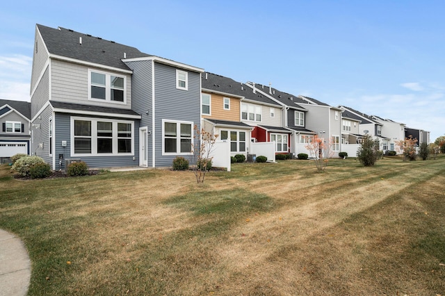 back of property with a lawn and a residential view