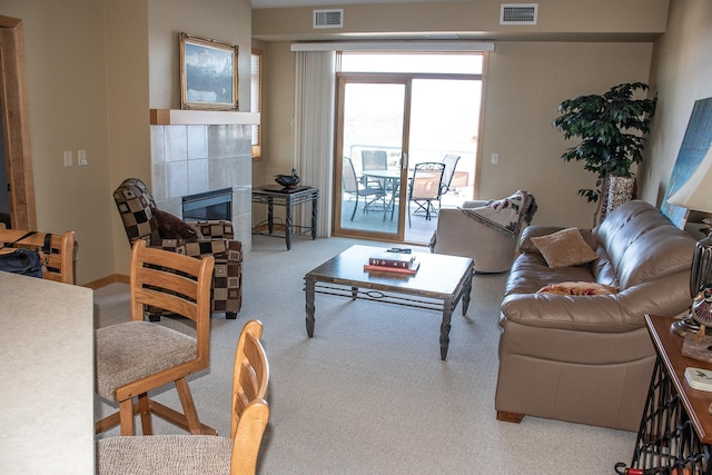 living room with visible vents and a tile fireplace