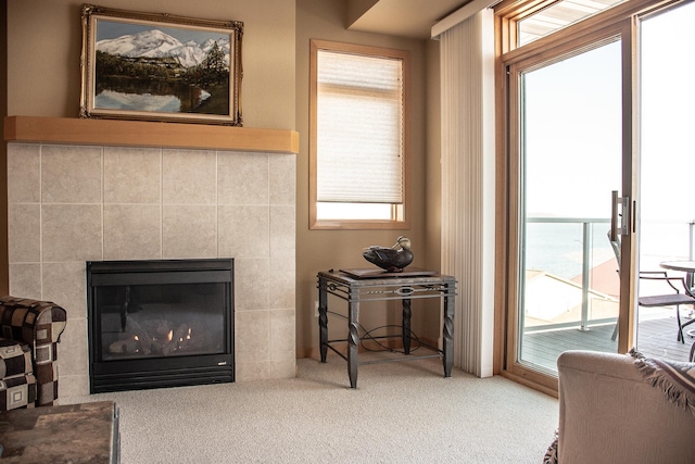 carpeted living area with a glass covered fireplace