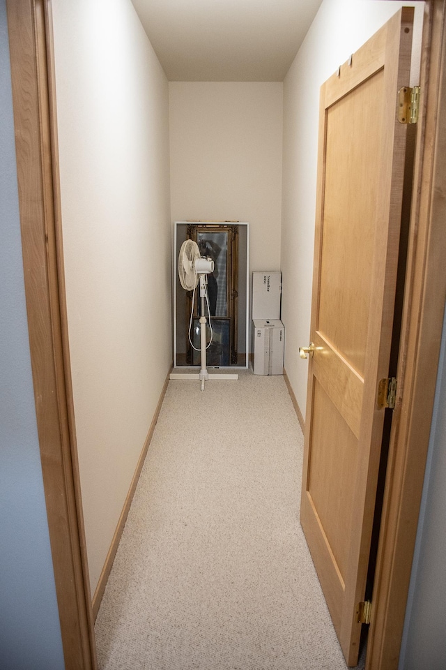 hall featuring baseboards and carpet floors
