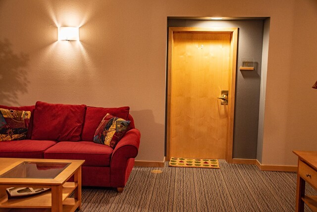 carpeted living area with baseboards