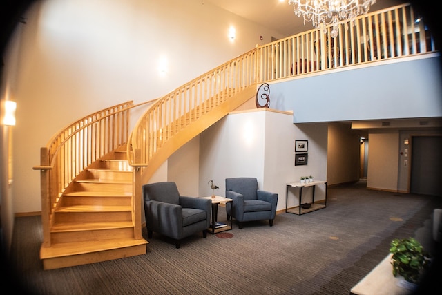 stairway with a high ceiling, a notable chandelier, baseboards, and carpet floors
