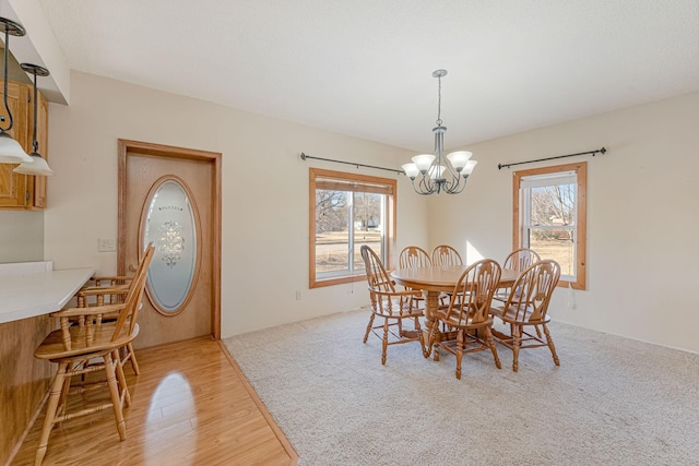 dining space with light wood-style flooring and a chandelier